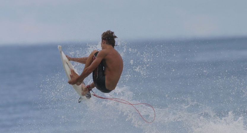 a person leaps into the air on a surfboard